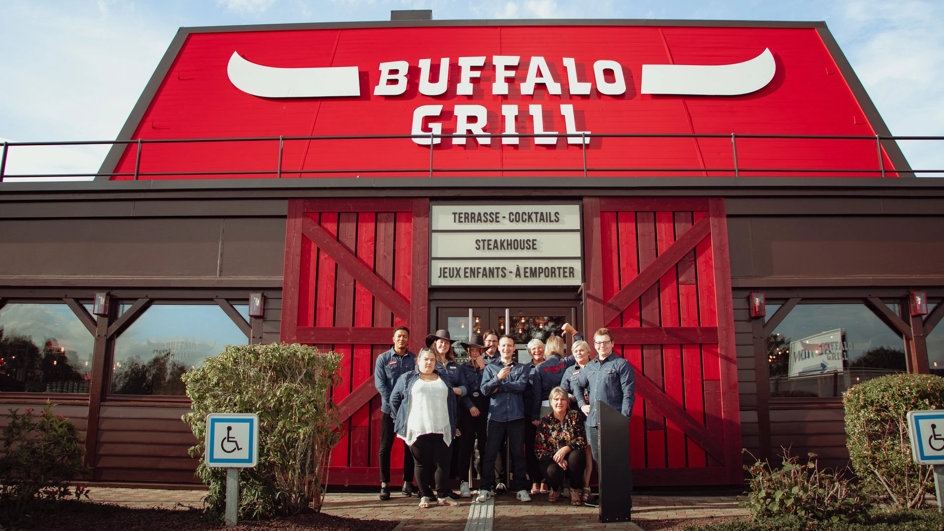 Equipe posant devant un restaurant Buffalo Grill