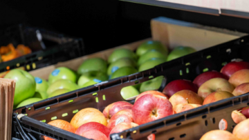 Des pommes vertes et rouges dans un rayon de magasin.