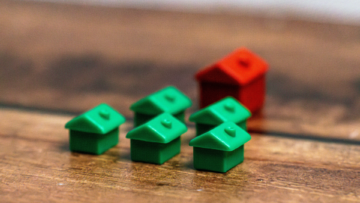 Cinq maisons vertes de monopoly et un hotel rouge.