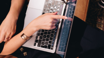 Une personne pointe quelque chose sur un écran d'ordinateur.