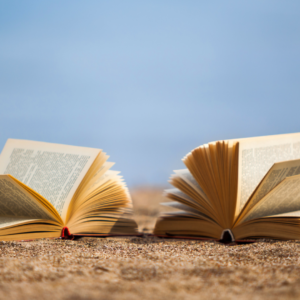 Deux livres ouverts sur une plage de sable.