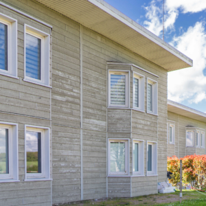 La façade d'une maison en bois clair.