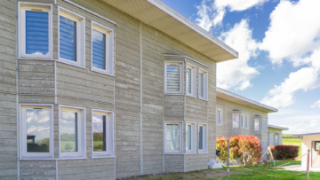 La façade d'une maison en bois clair.