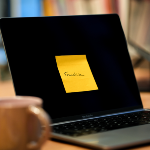 Un post it jaune collé sur un écran d'ordinateur sur lequel il est écrit "Franchise".