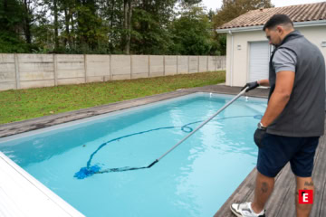 Salarié Quality Piscine entrain de nettoyer une piscine