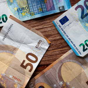 Ddes billets de 50 et de 20 euros posés sur une table en bois.