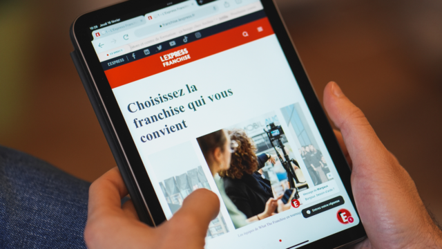 La page d'accueil de L'Express Franchise s'affiche sur une tablette.