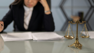 Une balance dorée devant une avocate.