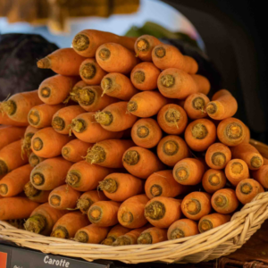 Une pyramide de carottes dans un magasin.