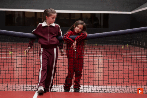 Enfants habillés en IKKS sur un terrain de tennis.