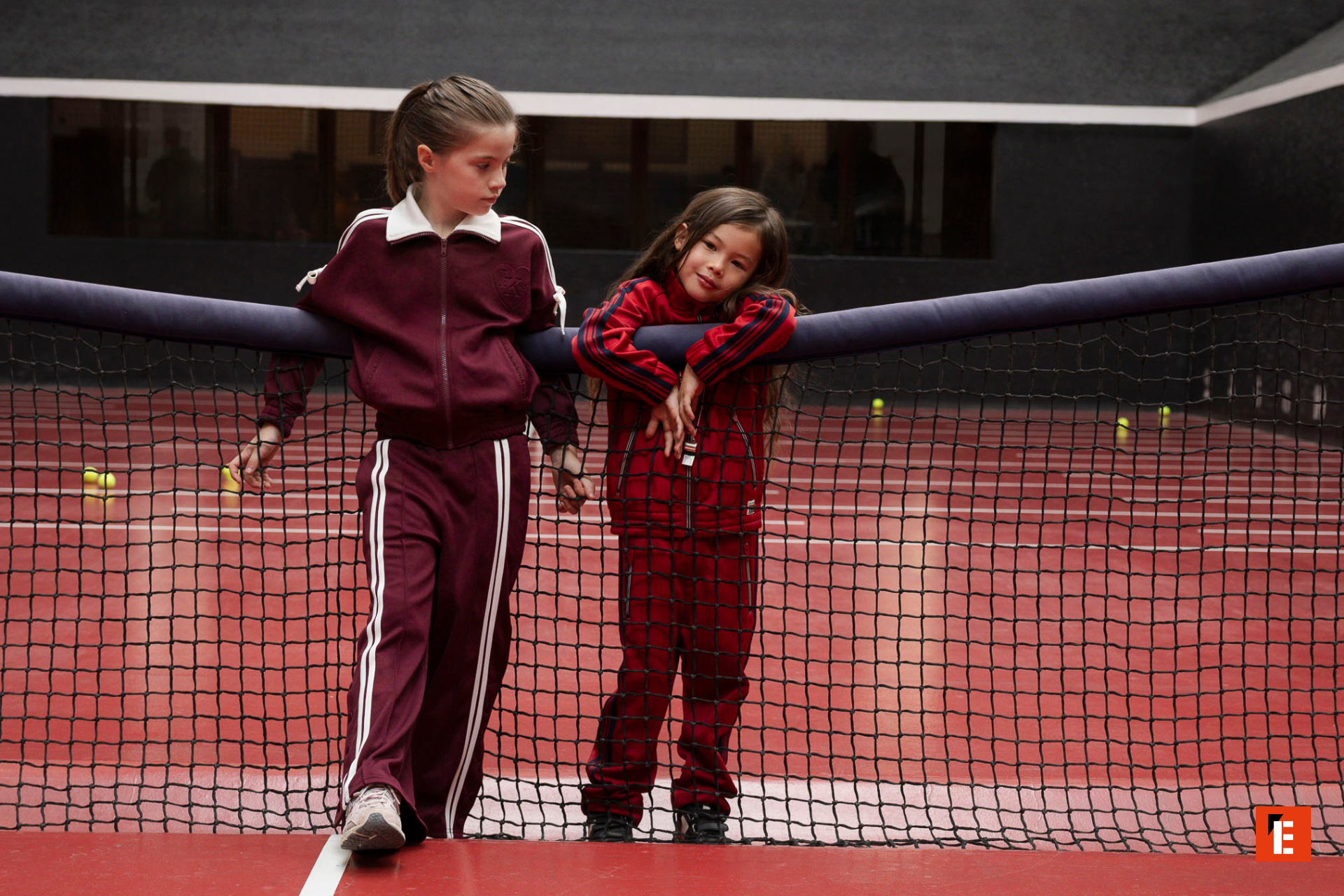 Enfants habillés en IKKS sur un terrain de tennis.