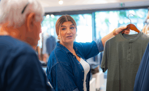 Une vendeuse tenant un article dans ses mains debout dans un magasin