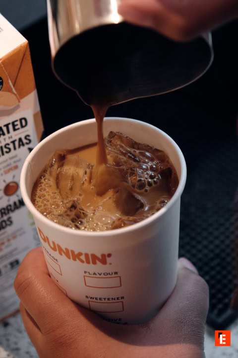 Versement de café glacé dans un verre.