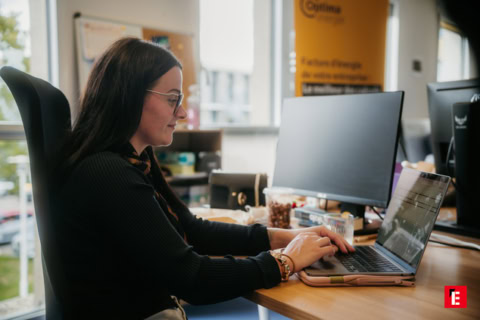 femme assise derrière un bureau face à son ordinateur