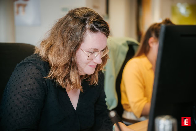 Femme travaillant sur un ordinateur en bureau.