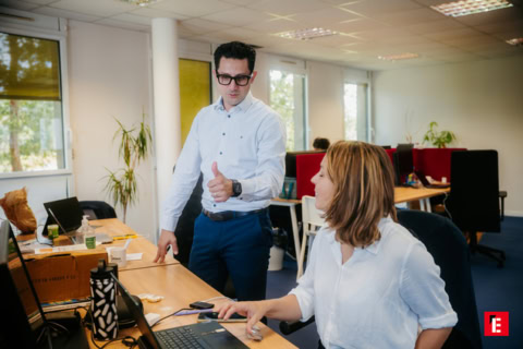 Deux collègues échangent des idées au bureau.