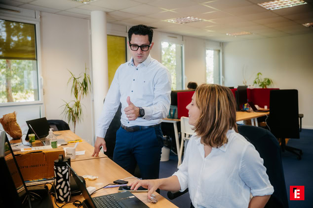 Deux collègues échangent des idées au bureau.