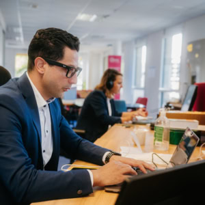 Homme portant un costard et chemise tapotant sur son clavier