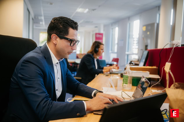 Homme portant un costard et chemise tapotant sur son clavier
