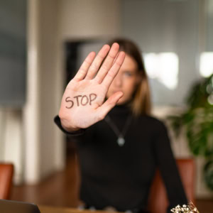 Une jeune femme la main tendue avec écrit Stop dessus.