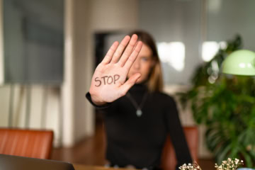 Une jeune femme la main tendue avec écrit Stop dessus.