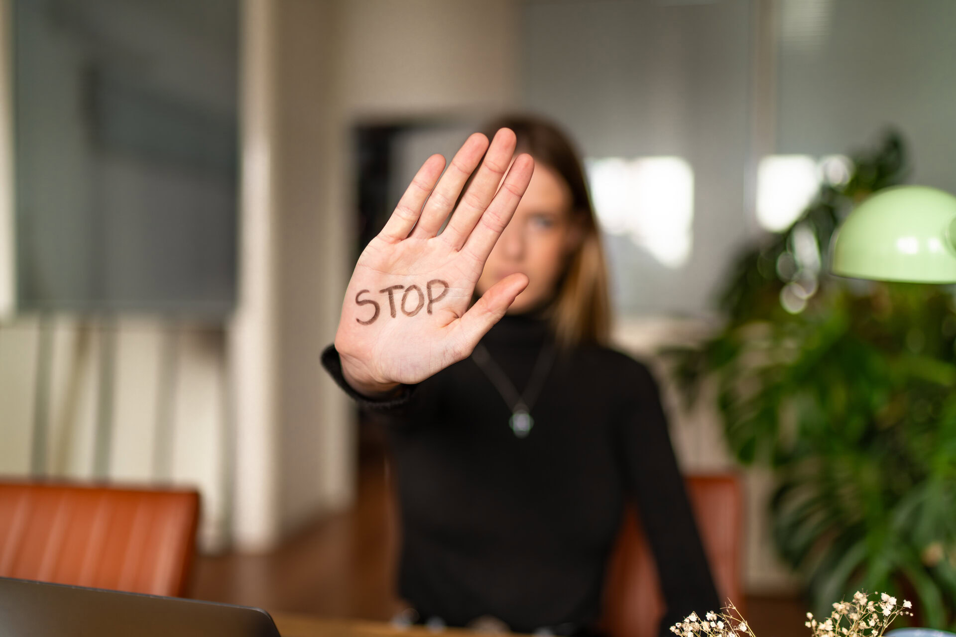 Une jeune femme la main tendue avec écrit Stop dessus.