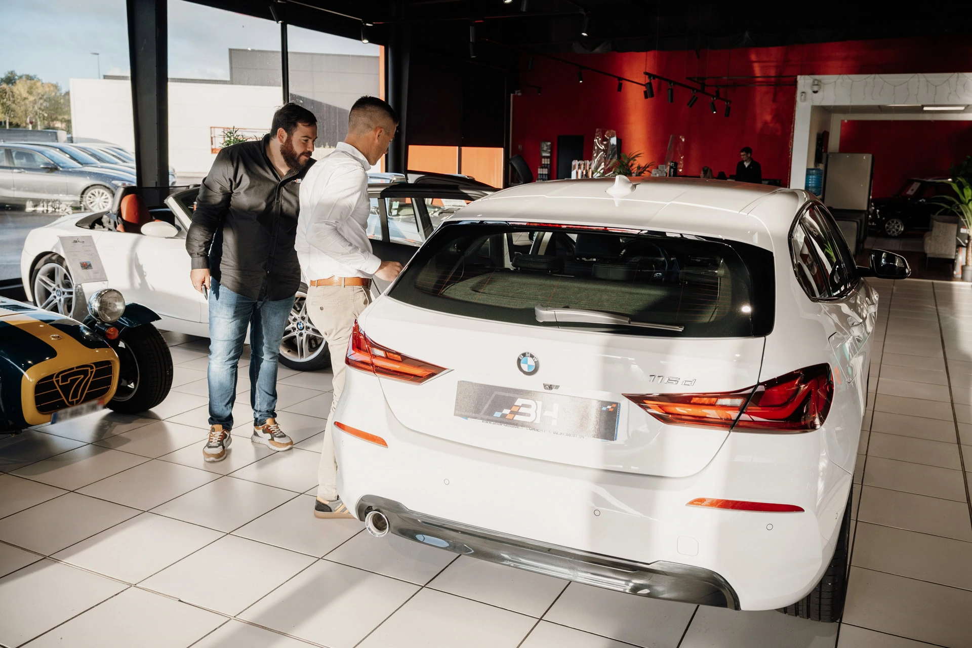2 hommes entrain de discuter dans une concession automobile