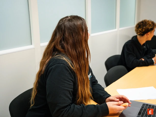Persona con cabello largo en una reunión.