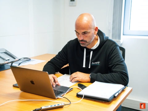 un hombre trabajando con un ordenador y papeles