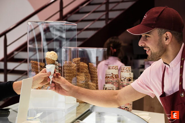 personne portant une casquette donnant un cornet de glace