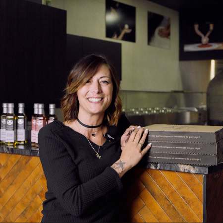 Laetitia, une cliente de la Dolce Serata adossée à un comptoir