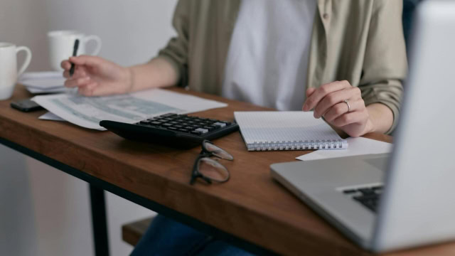 Personne à son bureau qui rempli des feuilles