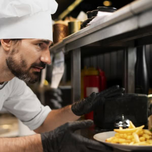 chef cuisinant dans la cuisine en portant une tenue professionnelle