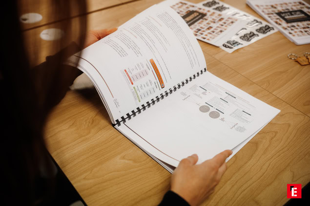 Une personne feuilletant un document professionnel.