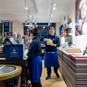 Vue de l'intérieur d'un magasin Leonidas avec des vendeurs et des clients