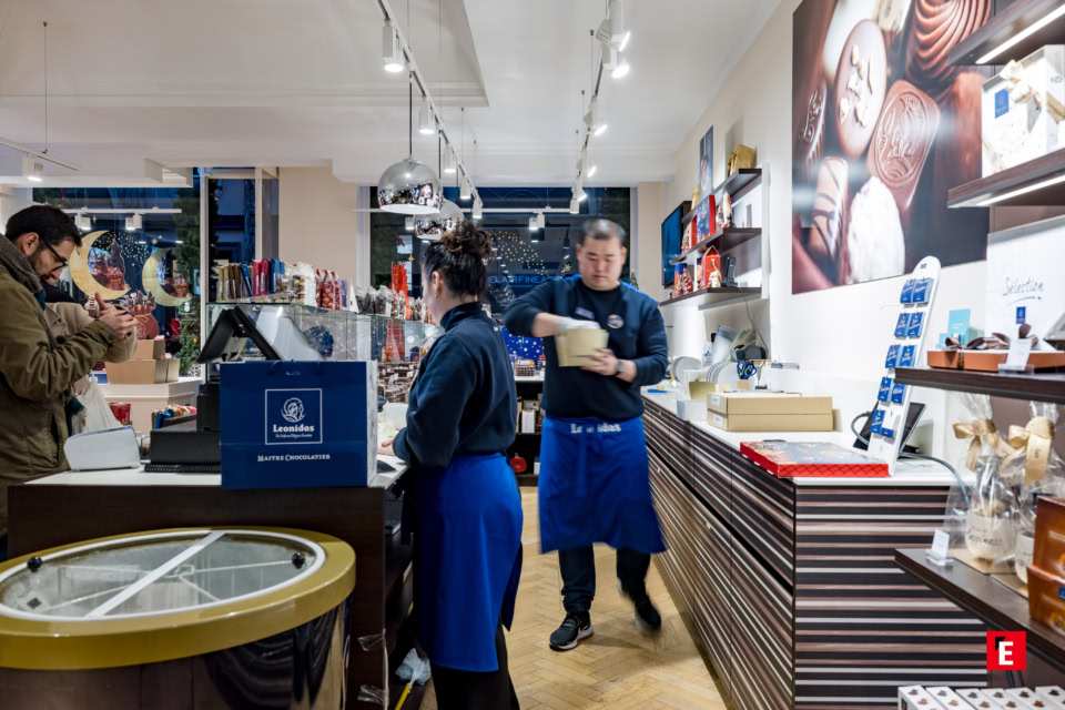 Vue de l'intérieur d'un magasin Leonidas avec des vendeurs et des clients