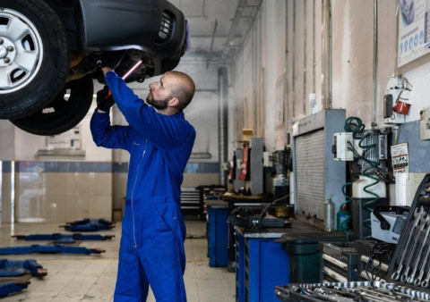 monsieur qui répare une voiture dans un garage