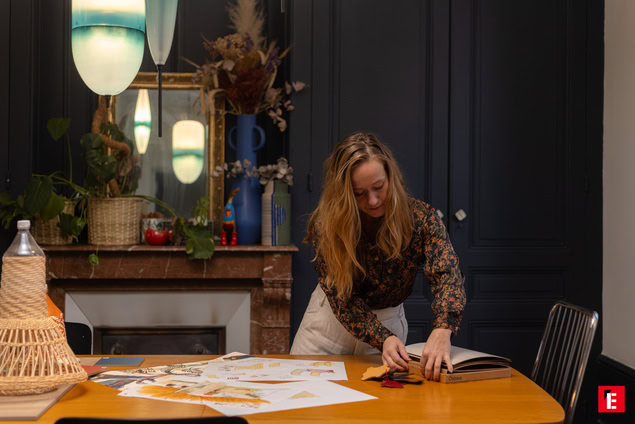 Femme créative travaillant sur une table en bois.