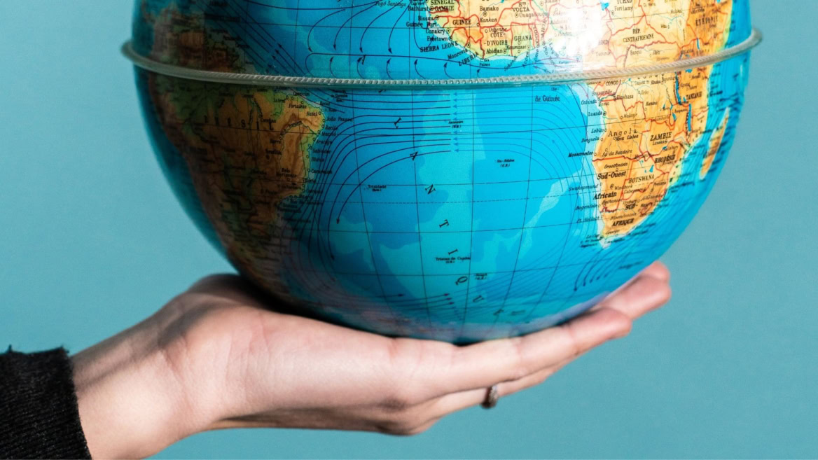 main qui tient une map monde