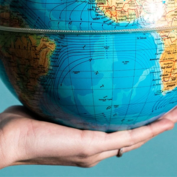 main qui tient une map monde