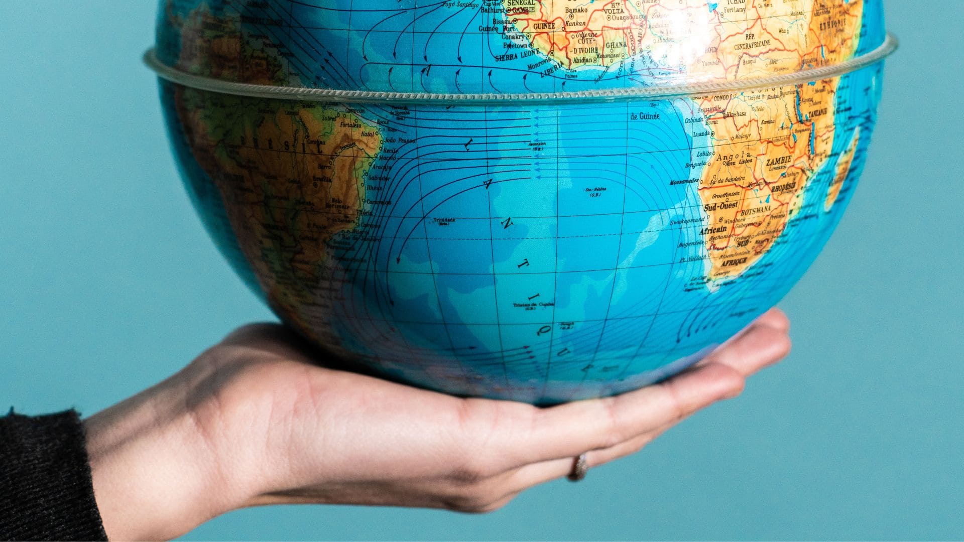 main qui tient une map monde