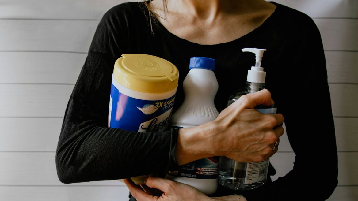 personne qui tient des produits de nettoyage
