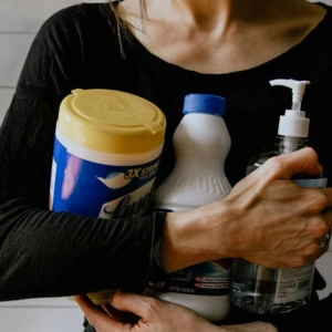 personne qui tient des produits de nettoyage