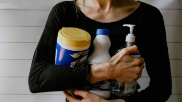 personne qui tient des produits de nettoyage