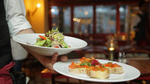 serveur avec des assiettes dans la main