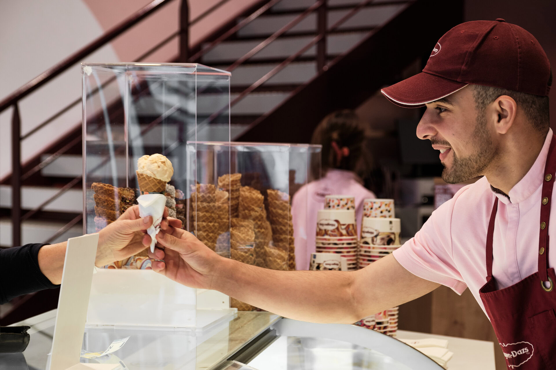vendeur souriant remet cornet de glace artisanale