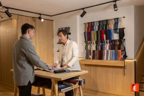 Tienda de ropa con espejo y estantes de madera.