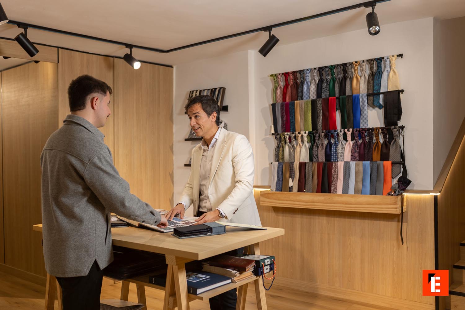 Tienda de ropa con espejo y estantes de madera.