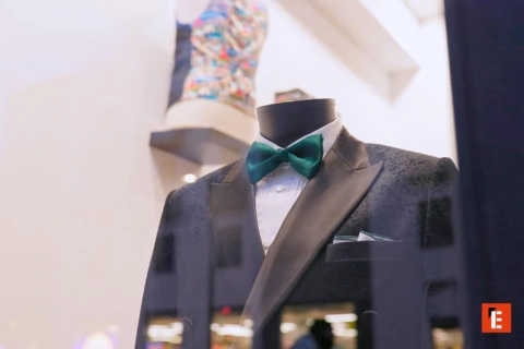 Ropa formal en perchas y zapatos en exhibición.