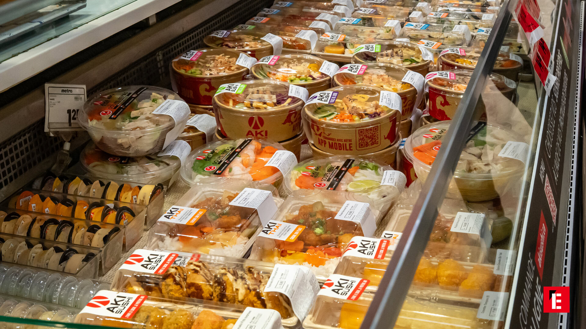 Femme souriante en veste orange dans un magasin.